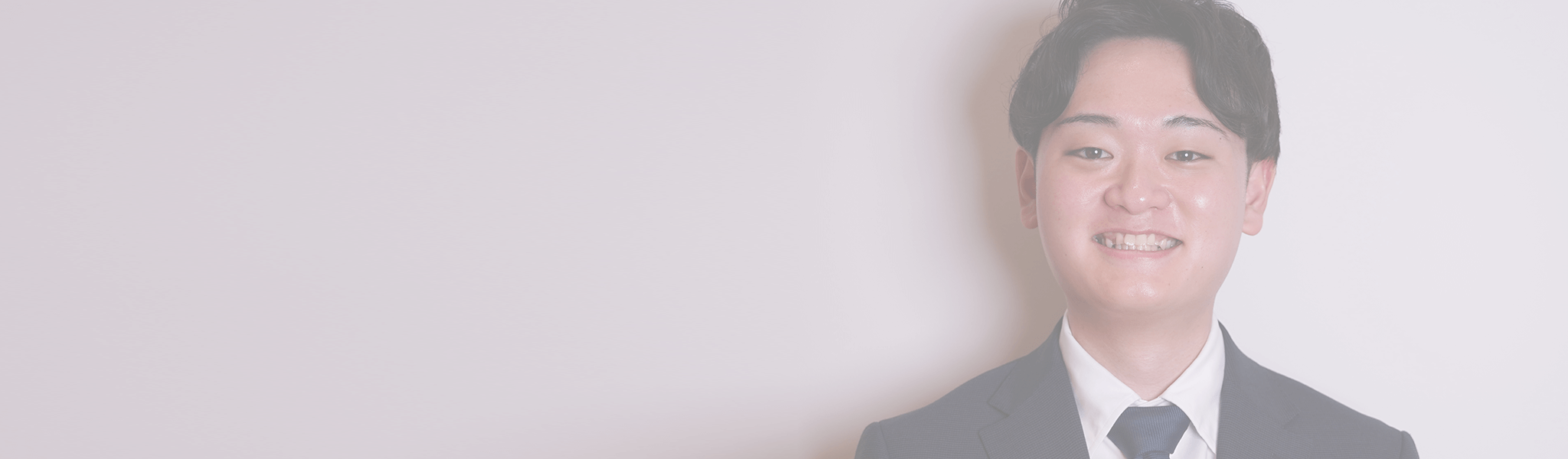 右側に笑顔の日本人男性を配置した、余白のあるインタビュー記事用メインビジュアル